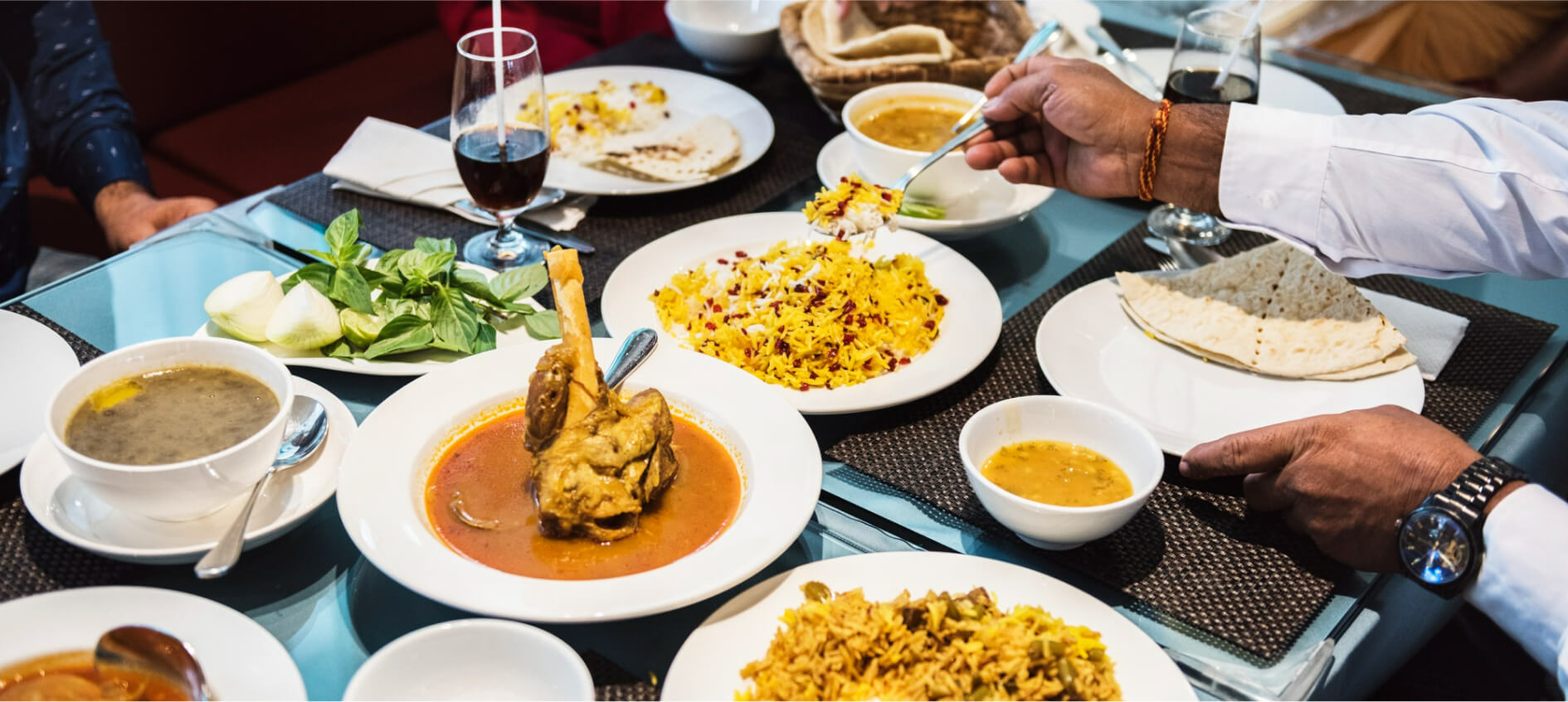 different dishes being served in different white plates and people are having their meal