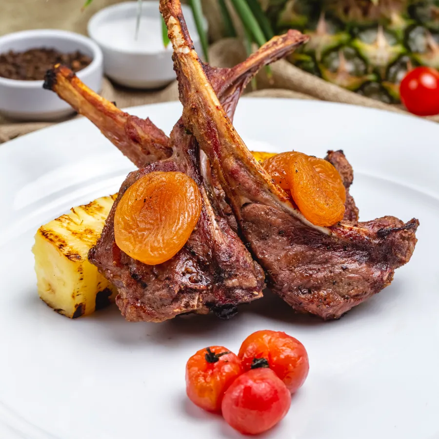 few pieces of chomps with some small tomatoes served in a white plate